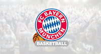 Das Logo von Bayern München und im Hintergrund eine Szene aus einem Basketballspiel.