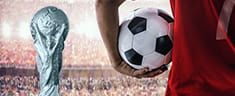 Der WM Pokal und ein Spieler mit Ball.
