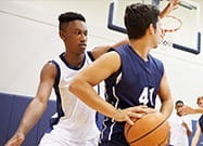 Zwei College Basketball Spieler in Aktion.