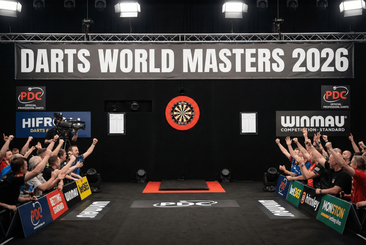 Eine Bühne mit einer Dartscheibe. Ein jubelndes Publikum neben der Bühne.